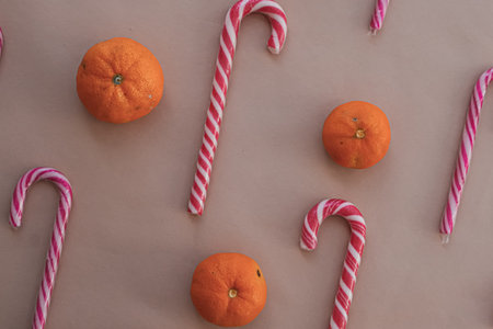 Close-Up of Candy Canes with Tangerines on Beige Background