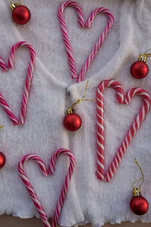 Vertical View of Heart-Shaped Candy Canes with Red Ornaments on White Sweater