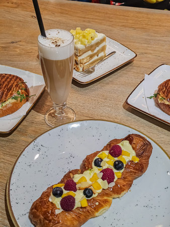 Side View of Latte Coffee with Pineapple Roll, Berry Tart