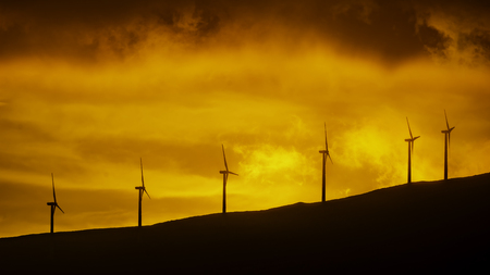 Wind turbines against an orange sunset at Maui Hawaii USAの写真素材