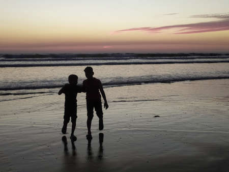 Cox's bazar Two brothers at the beach, the elder brother and his younger brother are standing and enjoying the evening sun setting, the elder brother telling his younger brother in detail about this sの写真素材