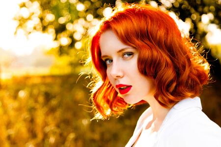 Beautiful redheaded woman face over autumn background