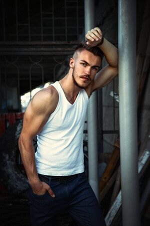 Portrait of attractive young man in a white shirt outdoorsの写真素材