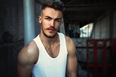 Portrait of attractive young man in a white shirt outdoorsの写真素材