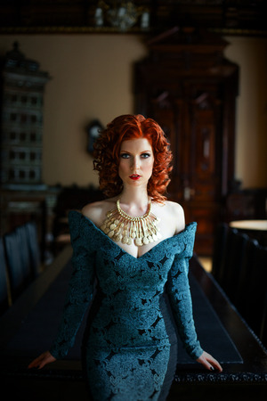 Pretty Woman with red curly hair wearing vintage blue dressの写真素材