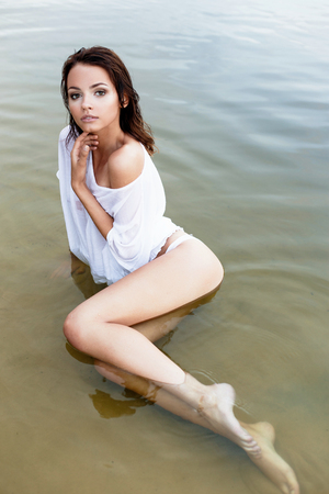 Beauty Sexy Model Girl Swimming and Posing in the Sea. Beautiful Woman Relaxing in turquoise Water. Sensual Girl enjoying the oceanの写真素材
