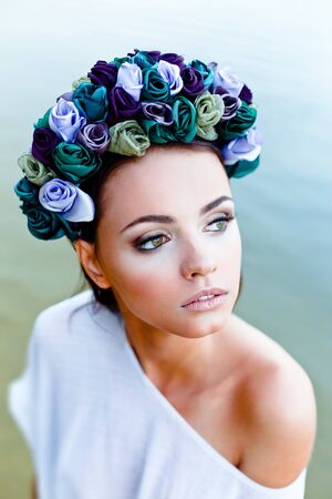 Sensual sexy woman wearing floral wreath standing in waterの写真素材
