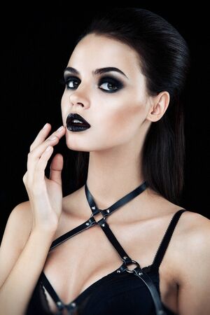 Pretty brunette female fashion model posing in studio with dark gothic make upの写真素材