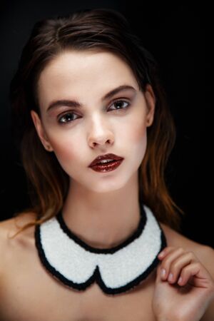 Pretty brunette female model face posing in studio with necklaceの写真素材