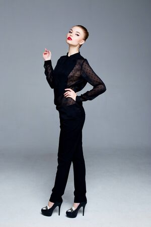 Beautiful young brunette woman posing in studio. red lipstick.の写真素材
