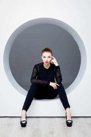 Sexy woman posing in circle hole in wallの写真素材