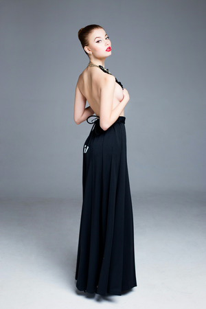 Beautiful sensual topless woman in long skirt with necklaceの写真素材
