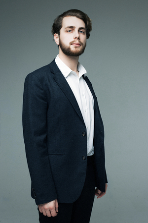 Handsome man in suit on grey backgroundの写真素材