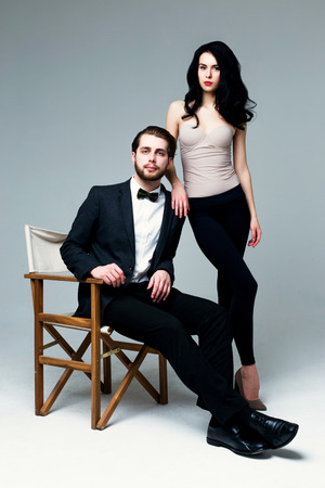Handsome man in suit and pretty brunette female model on grey backgroundの写真素材