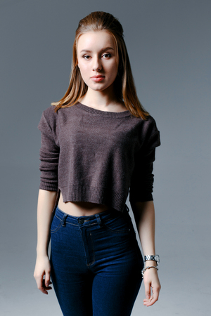 Fashion Model girl isolated over gray background. Beauty stylish woman posing in fashionable clothes. Casual style. High fashion, urban styleの写真素材