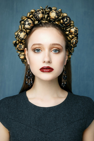 Portrait of a beautiful young woman in a wreath on had. Beauty female. Perfect skin and make up.の写真素材