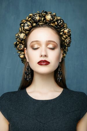 Portrait of a beautiful young woman in a wreath on had. Beauty female. Perfect skin and make up.の写真素材