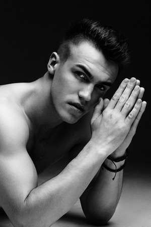 Portrait of a handsome topless man inflated lying on the floor on dark background black and white photoの写真素材