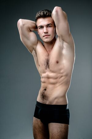 Young fashion topless man isolated on dark backgroundの写真素材