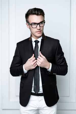 Portrait of handsome stylish man in elegant black suit wearing eyeglassesの写真素材