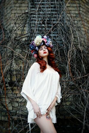 Sensual sexy woman face wearing floral wreath on brick wall backgroundの写真素材