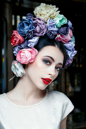 Portrait of a beautiful young woman in a wreath on had. beauty girl with red lips. Female face with clear skin close-up. Skincareの写真素材