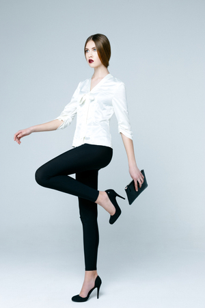 Beautiful woman in white blouse on gray backgroundの写真素材