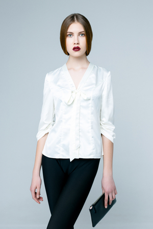 Beautiful woman in white blouse on gray backgroundの写真素材