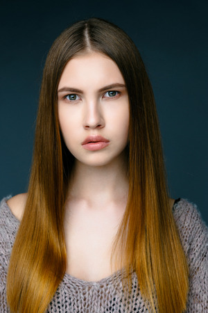 Beauty fashion girl. Portrait of beautiful young woman with fresh clean skin on grey backgroundの写真素材