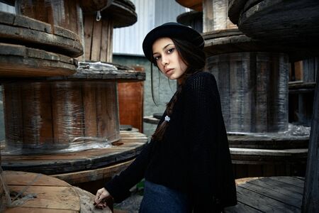 beautiful young woman lady posing outdoors wearing black hatの写真素材