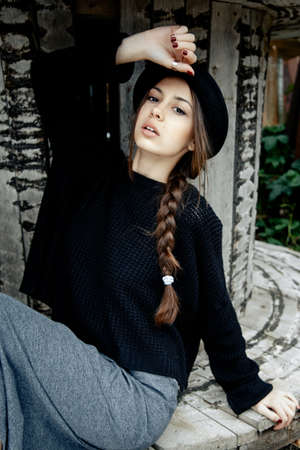beautiful young woman lady posing outdoors wearing black hatの写真素材