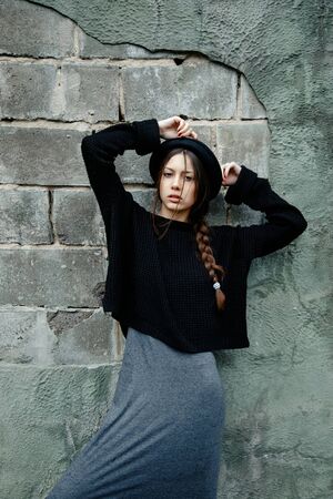 beautiful young woman lady posing outdoors wearing black hatの写真素材