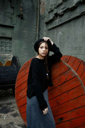 beautiful young woman lady posing outdoors wearing black hatの写真素材