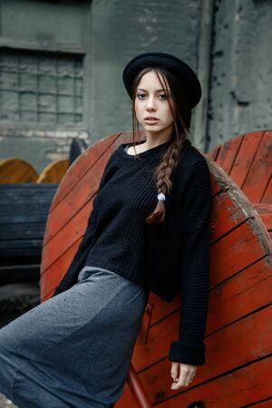 beautiful young woman lady posing outdoors wearing black hatの写真素材