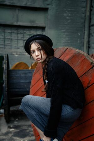 beautiful young woman lady posing outdoors wearing black hatの写真素材
