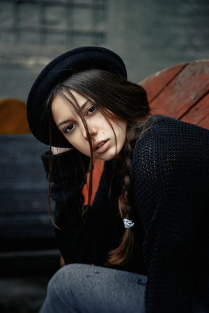 beautiful young woman lady posing outdoors wearing black hatの写真素材