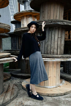 beautiful young woman lady posing outdoors wearing black hatの写真素材