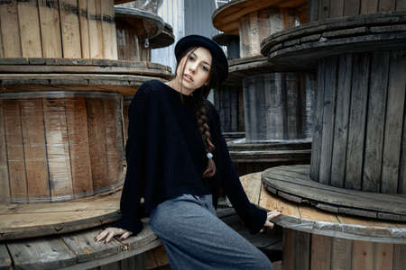 beautiful young woman lady posing outdoors wearing black hatの写真素材