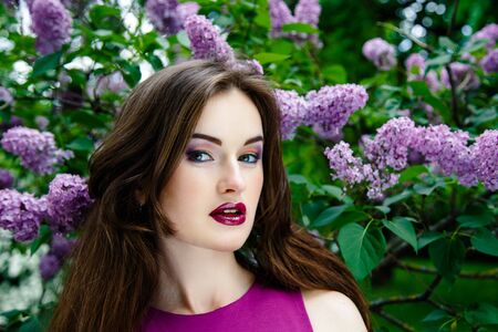 Portrait of Beautiful woman with fashion makeup with beautiful lilac flowers,の写真素材