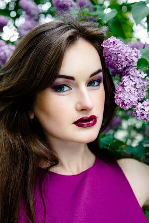 Portrait of Beautiful woman with fashion makeup with beautiful lilac flowers,の写真素材