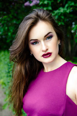 Portrait of Beautiful woman with fashion makeup with beautiful lilac flowers,の写真素材
