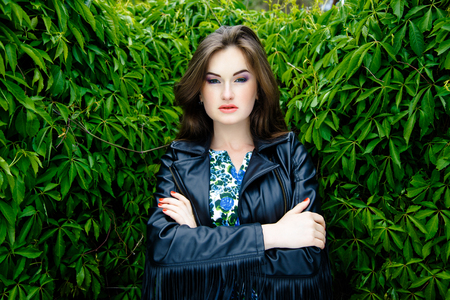 Glamorous young woman in black leather jacket outdoorsの写真素材