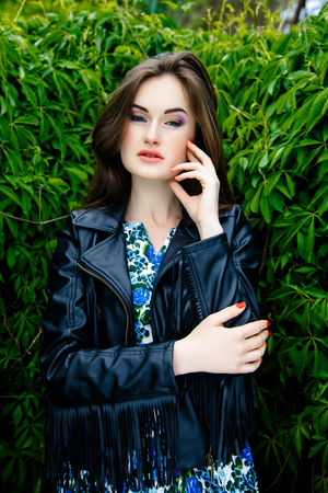 Glamorous young woman in black leather jacket outdoorsの写真素材