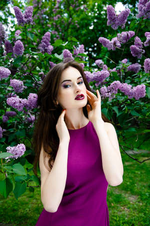 Portrait of Beautiful woman with fashion makeup with beautiful lilac flowers,の写真素材