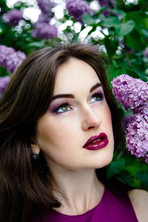 Portrait of Beautiful woman with fashion makeup with beautiful lilac flowers,の写真素材