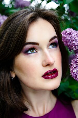 Portrait of Beautiful woman with fashion makeup with beautiful lilac flowers,の写真素材