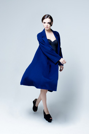 Young pretty woman face with false feather eyelashes fashion makeup wearing blue coatの写真素材