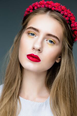 Sensual sexy woman face wearing floral red wreath and red lipsの写真素材