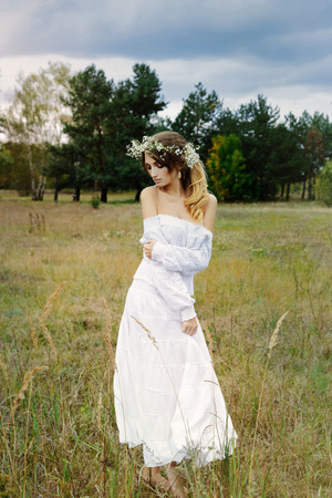 Close up portrait of woman face wearing floral white wreath outdoorsの写真素材