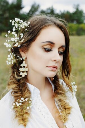 Close up portrait of woman face wearing floral white wreath outdoorsの写真素材